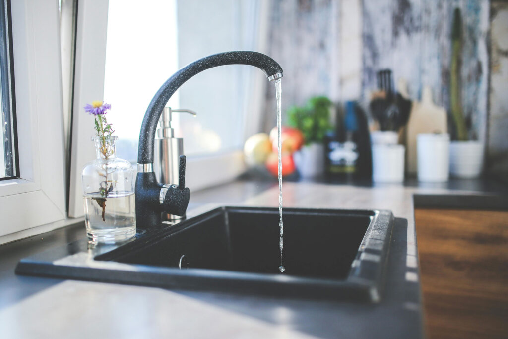 black kitchen faucet sink running water