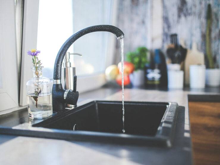 black kitchen faucet sink running water