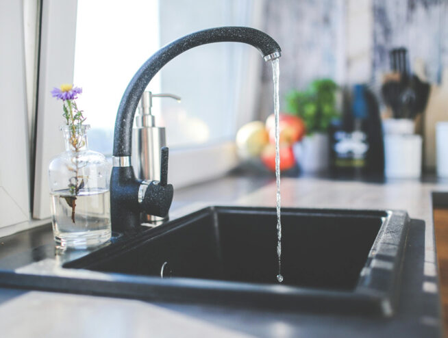 black kitchen faucet sink running water